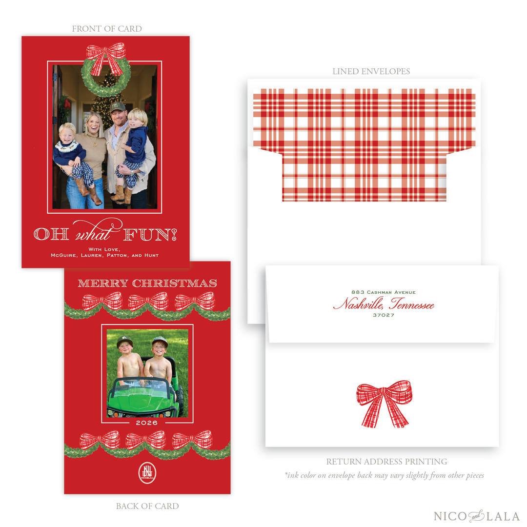 Customizable holiday photo card and envelope set by Nico & Lala, featuring a red background card front with a photo upload and 'Oh What Fun!' text with a wreath topping the photo area. The back of the card has another photo upload area, and green garland motif. A red and white plaid liner is shown along with the envelope return address in red with a red bow. 